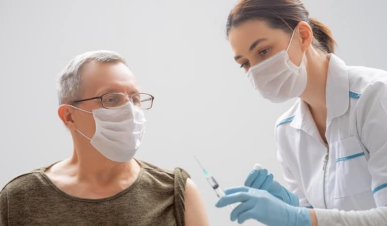 a man wearing a mask has a vaccine